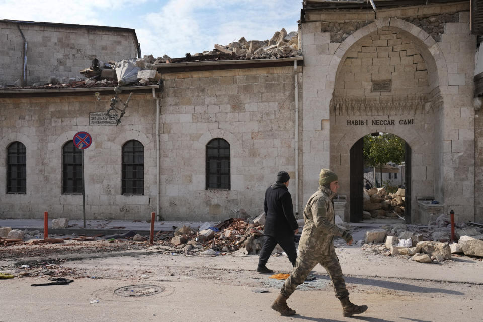 A Turkish soldier walks past the main entrance of the historic Habib Najjar mosque which destroyed during the devastated earthquake, in the old city of Antakya, Turkey, Saturday, Feb. 11, 2023. Antakya, known as Antioch in ancient times, has been destroyed many times by earthquakes. It was destroyed yet again by an earthquake earlier this month, and residents are wondering if its ancient glories will ever come back. (AP Photo/Hussein Malla)