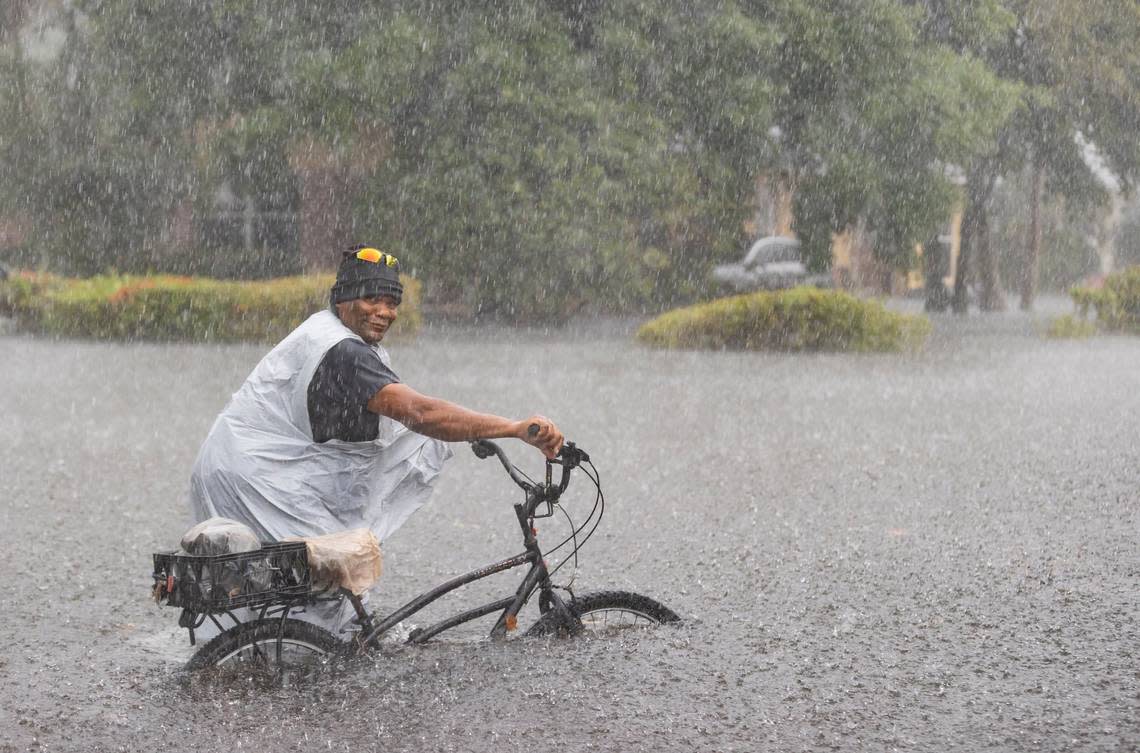 Leon rides his bike down a flooded street in the Edgewood neighborhood on Thursday, April 13, 2023, in Fort Lauderdale, Fla. A torrential downpour severely flooded streets partially submerging houses and cars across South Florida.