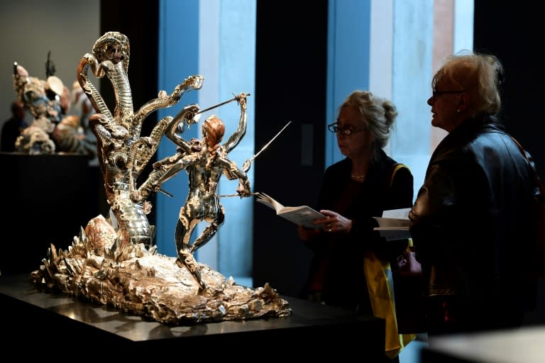 People look at a silver sculture titled "Hydra and Kali" by British artist Damien Hirst during the press presentation of his exhibit "Treasures from the Wreck of the Unbelievable" at the Pinault Collection in Venice on April 6, 2017