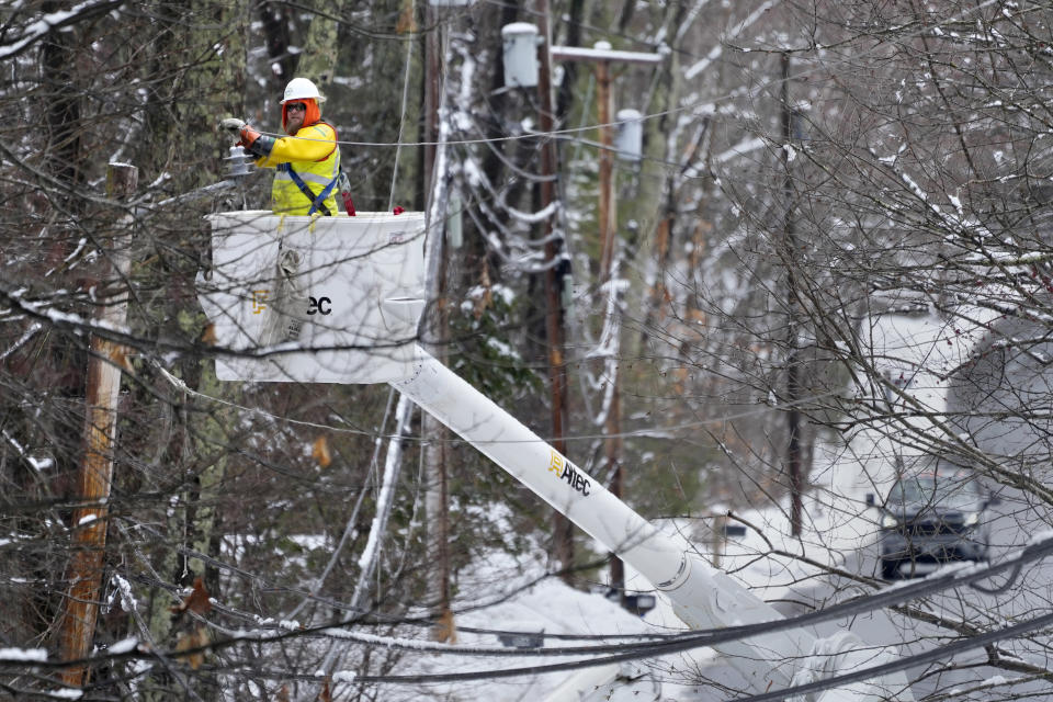 A utility worker strings a line, Friday, April 5, 2024, in Derry, N.H. Many New Englanders are cleaning up following a major spring storm on Thursday that brought heavy snow, rain and high winds to the Northeast. Hundreds of thousands of homes and businesses are still without power in Maine and New Hampshire. (AP Photo/Charles Krupa)