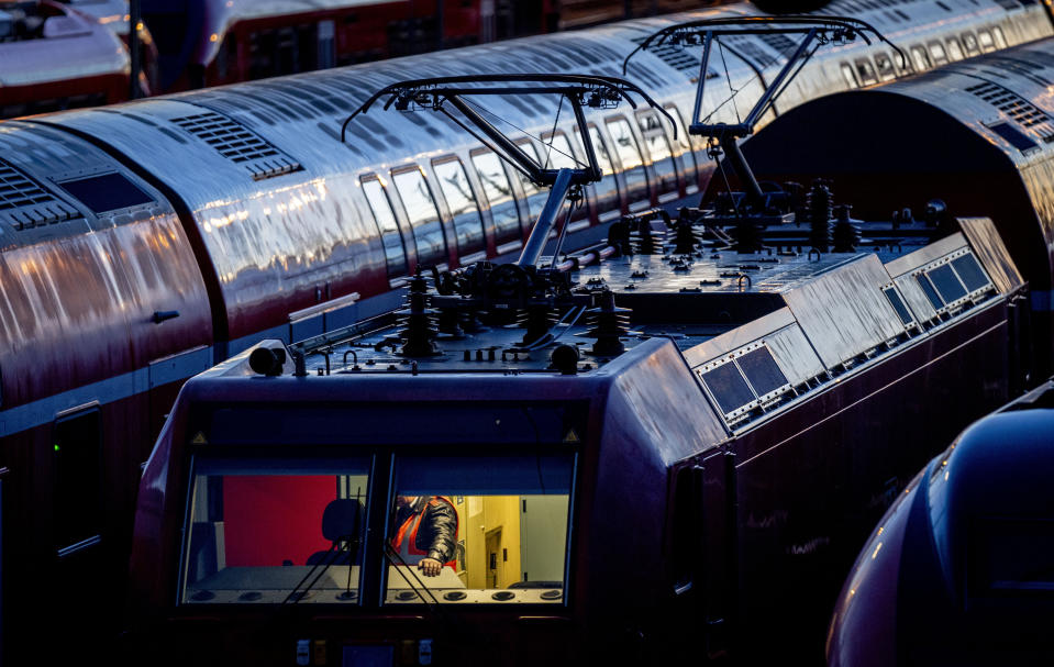 A Deutsche Bahn employee checks a train near the central train station in Frankfurt, Germany, Monday, March 27, 2023. Germany faces a nationwide public transport strike on Monday. (AP Photo/Michael Probst)