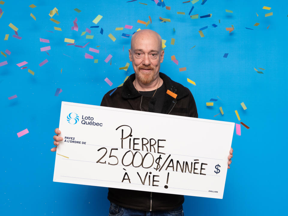 Quebec man holding a lotto cheque. 