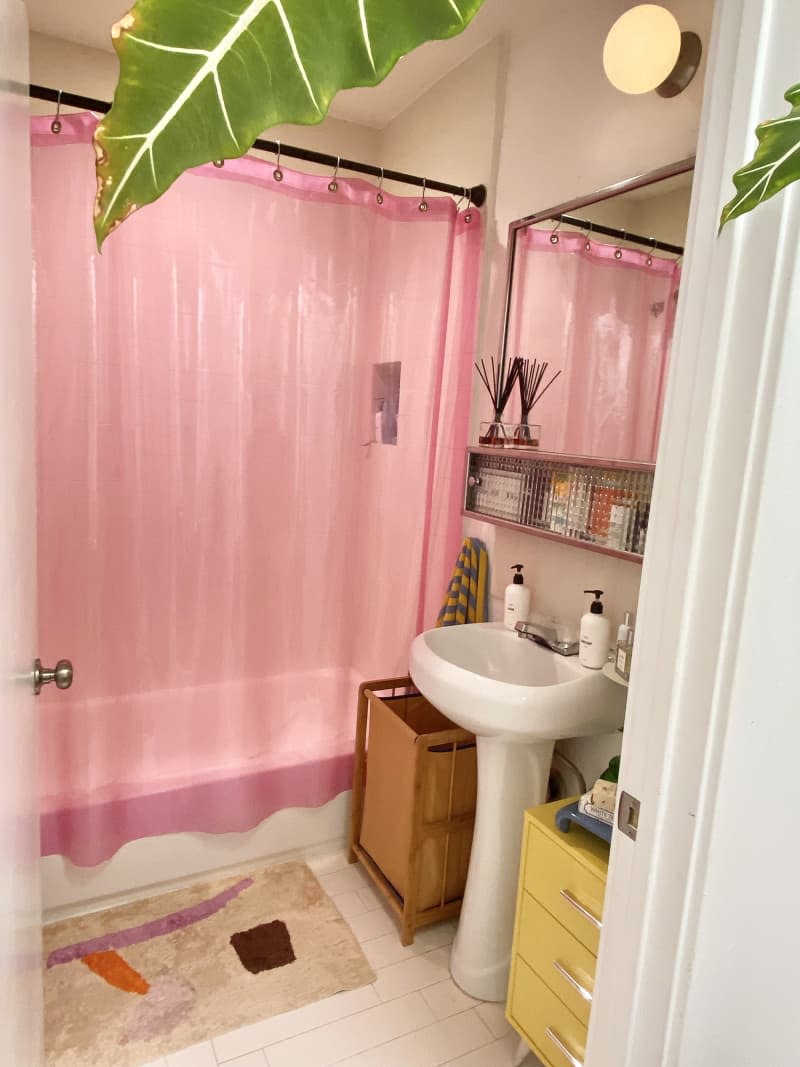 white bathroom with pink shower curtain