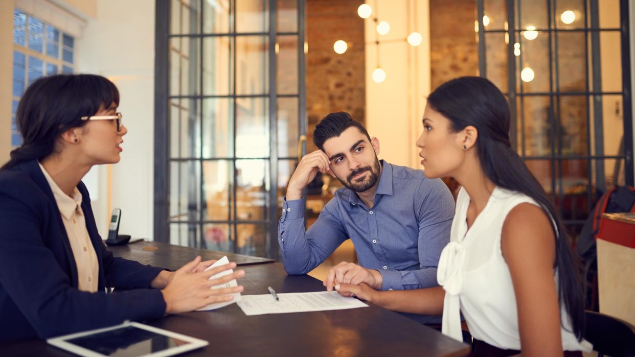 Shot of a young couple meeting with a financial planner in an office.