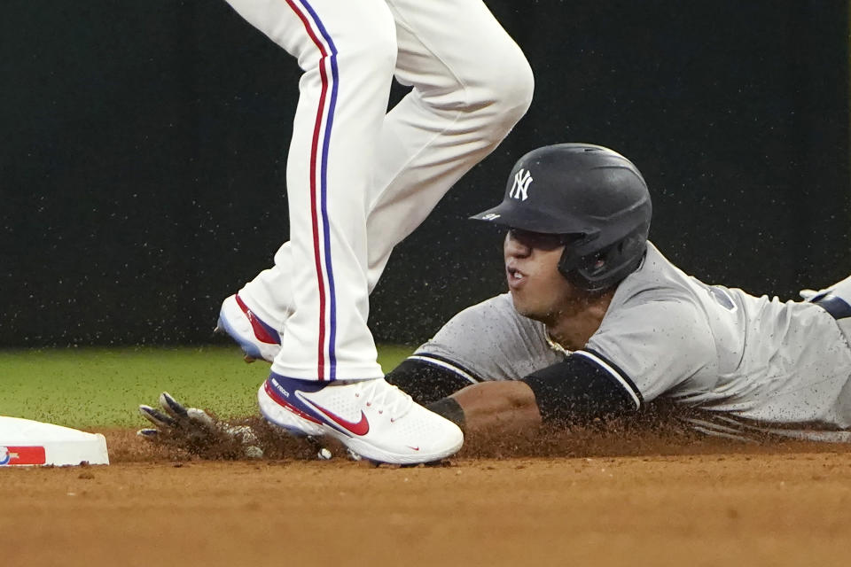 New York Yankees Oswald Peraza, bottom, slides in under Texas Rangers second baseman Marcus Semien (2) to steal second base during the fifth inning in the first baseball game of a doubleheader in Arlington, Texas, Tuesday, Oct. 4, 2022. (AP Photo/LM Otero)