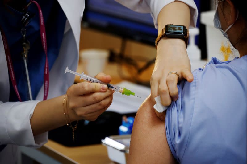 FILE PHOTO: A health worker gets a dose of the Pfizer-BioNTech coronavirus disease (COVID-19) vaccine at a COVID-19 vaccination center in Seoul