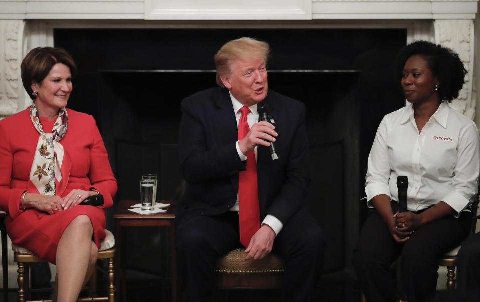 FILE - In this July 25, 2019, file photo, President Donald Trump, joined by Shameka Whaley Green of Toyota, right, and Marillyn Hewson, Chairman, President and CEO, Lockheed Martin, left, speaks during a 'Pledge to America's Workers" ceremony in the State Dining Room of the White House in Washington. If there was one day that crystallized all the forces that led to the impeachment investigation of President Donald Trump, it was July 25. That was the day of his phone call with Ukraine’s new leader, pressing him for a political favor. (AP Photo/Carolyn Kaster, File)