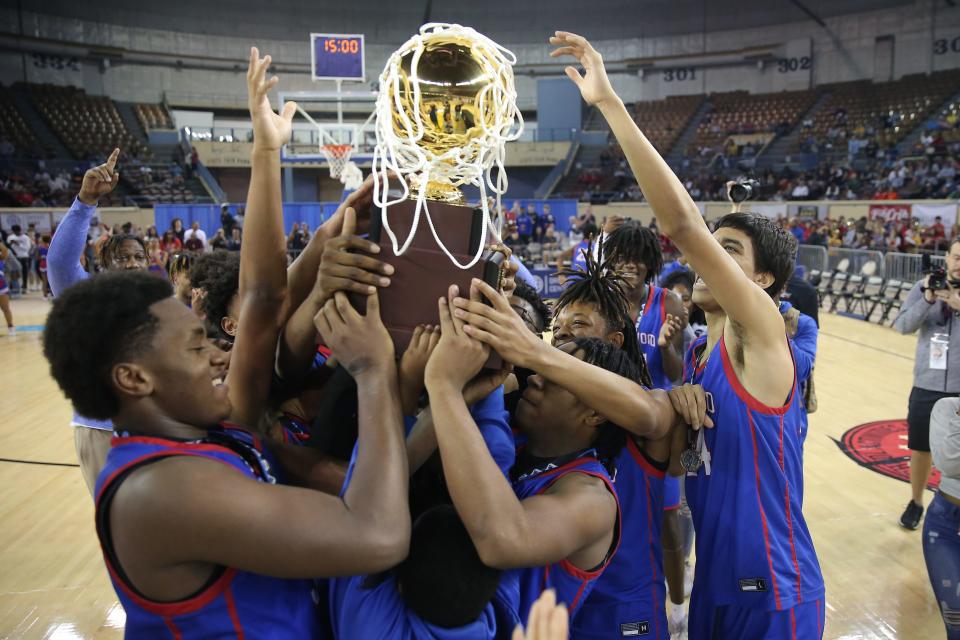 Millwood celebrates with the trophy March 11 after winning the Class 3A boys basketball state championship against Metro Christian at State Fair Arena in Oklahoma City.
