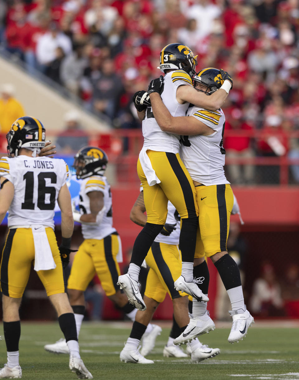 Iowa's Henry Marchese (13), left, and Logan Lee (85) celebrate a fumble recovery against Nebraska during the second half of an NCAA college football game Friday, Nov. 26, 2021, at Memorial Stadium in Lincoln, Neb. Iowa defeated Nebraska 28-21. (AP Photo/Rebecca S. Gratz)