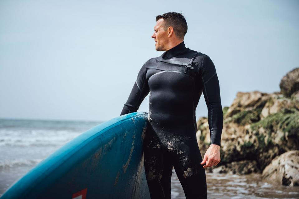 Person surfing/paddle boarding wearing wetsuit