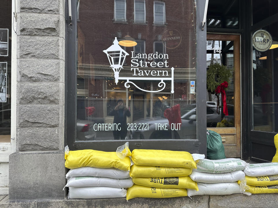 Sand bags sit on a street in Montpelier, Vt., on Tuesday, Dec. 19, 2023, a day after the threat of flooding hit the city again. Many communities were saturated by rainfall. Some towns in Vermont, which had suffered major flooding from a storm in July, were seeing more flood damage. (AP Photo/ Lisa Rathke)