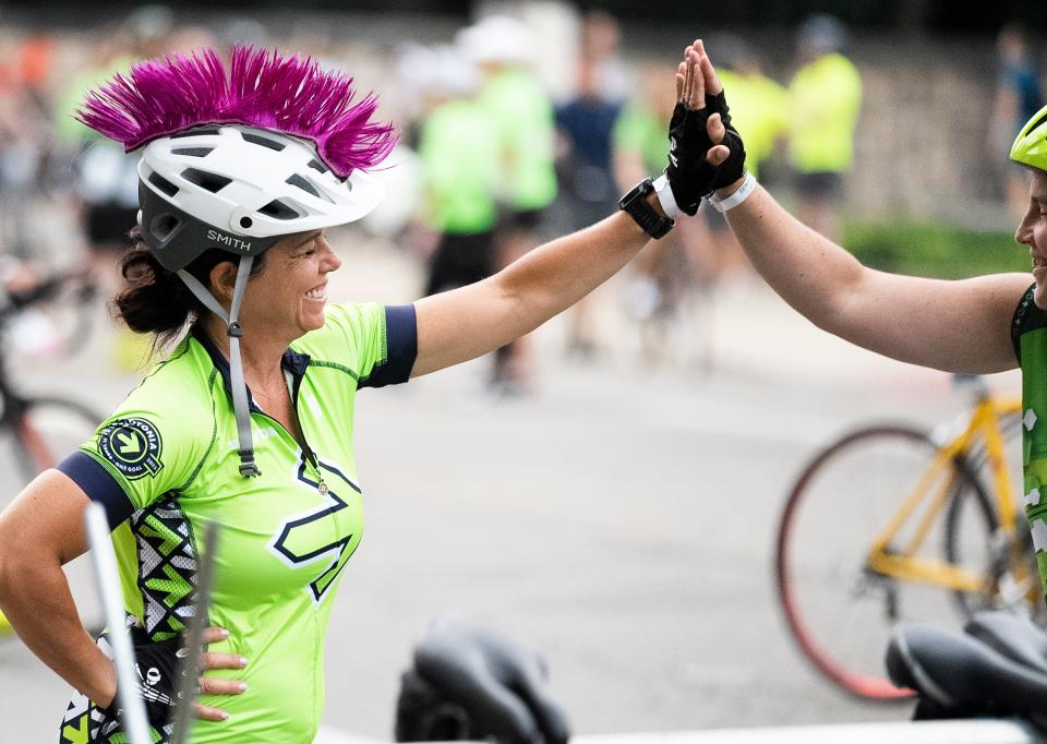 Aug 5, 2023; Columbus, Ohio, U.S.;  Michelle Smith high-fives Sarah Brownlee before their 50 mile ride on the fifteenth year of the Pelotonia ride to fund cancer research. 