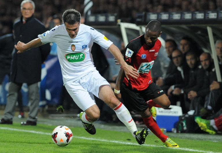 Monaco's Jeremy Toulalan fights off a tackle from Guingamp's Claudio Beauvue during their French Cup semi-final on April 16, 2014 at the Roudourou stadium