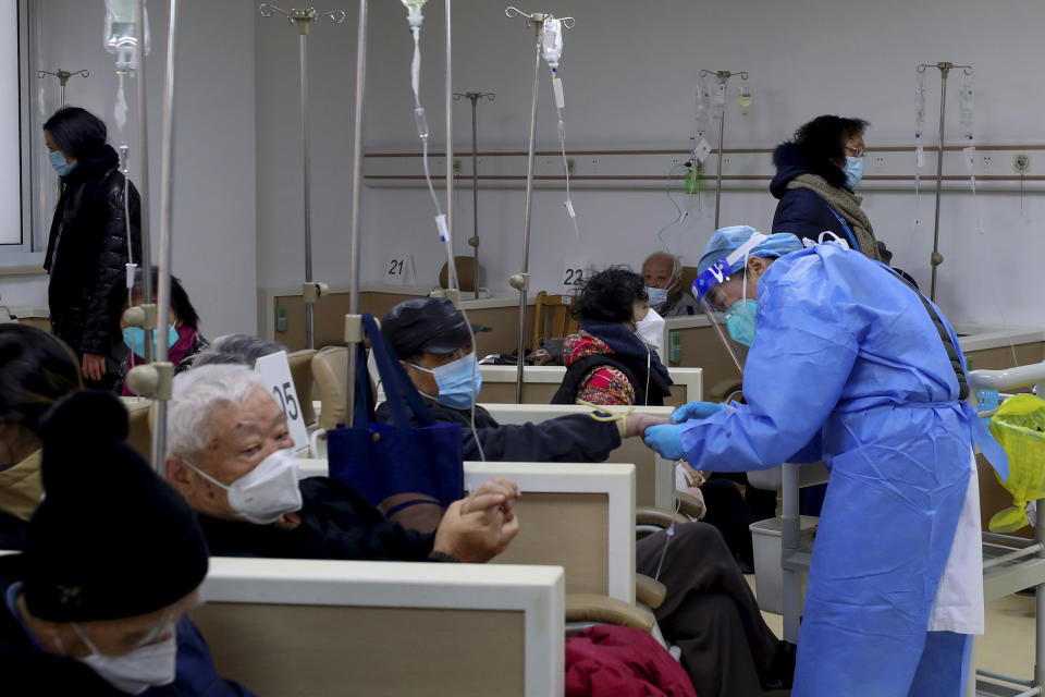In this photo released by Xinhua News Agency, A medical worker helps a patient on the intravenous drip at a community healthcare institution in Shanghai, China, Monday, Jan. 5, 2023. As COVID-19 rips through China, other countries and the WHO are calling on its government to share more comprehensive data on the outbreak, with some even saying many of the numbers it is reporting are meaningless. (Fang Zhe/Xinhua via AP)