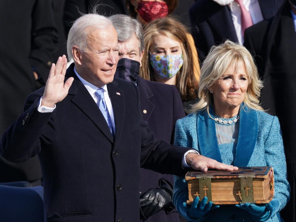 Joe Biden is sworn in as the 46th president of the United States on the West Front of the Capitol while his wife Jill Biden holds a bible. The president welcomed a ‘day of history and hope’ after taking the oath of office saying: ‘This is America’s day. This is democracy’s day.’REUTERS