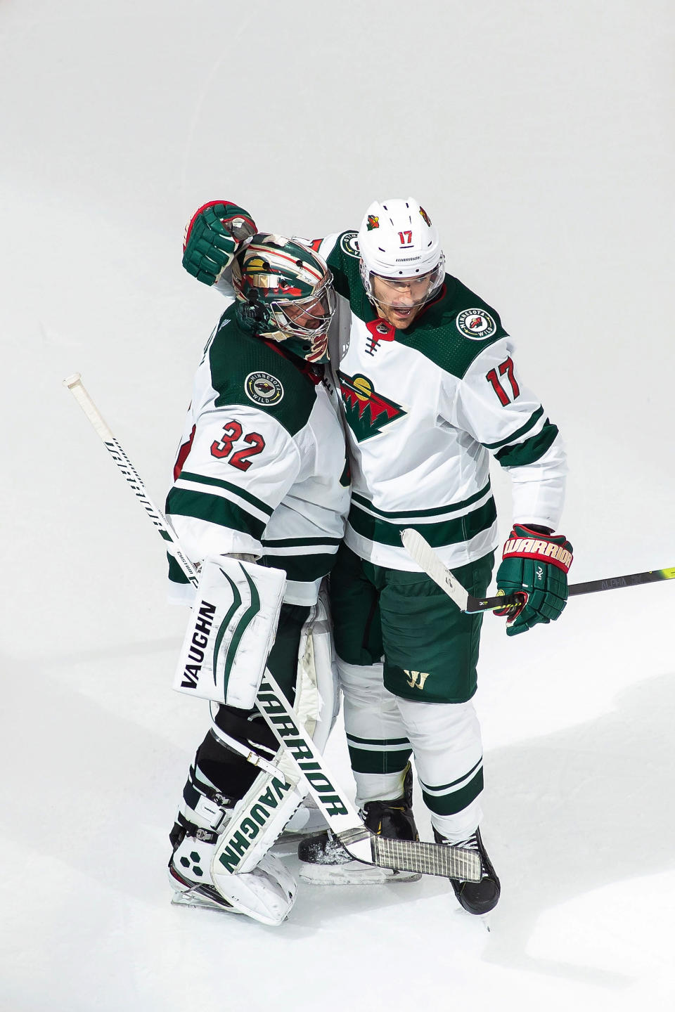 Minnesota Wild goaltender Alex Stalock (32) and teammate Marcus Foligno (17) celebrate the team's 3-0 win over the Vancouver Canucks in NHL hockey playoff game Sunday, Aug. 2, 2020, in Edmonton, Alberta. (Codie McLachlan/The Canadian Press via AP)