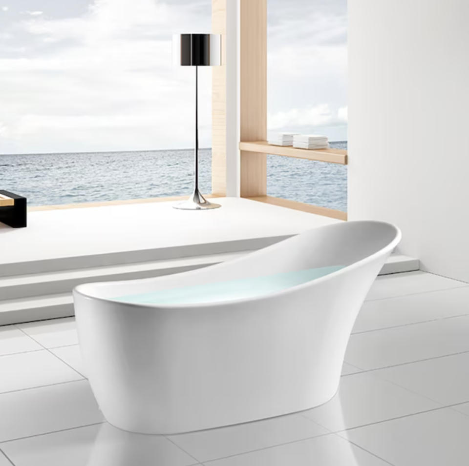 filled tub in bathroom with ocean view