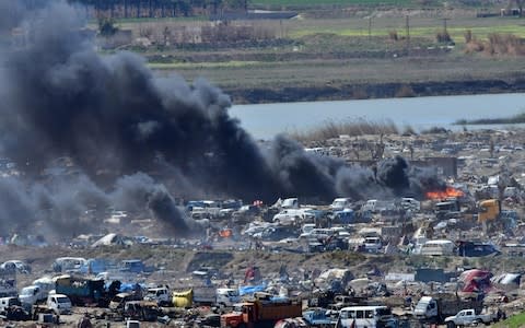 Heavy smoke rises above Isil's last remaining position in the village of Baghouz during battles with the SDF, in the countryside of the eastern Syrian province of Deir Ezzor - Credit: AFP