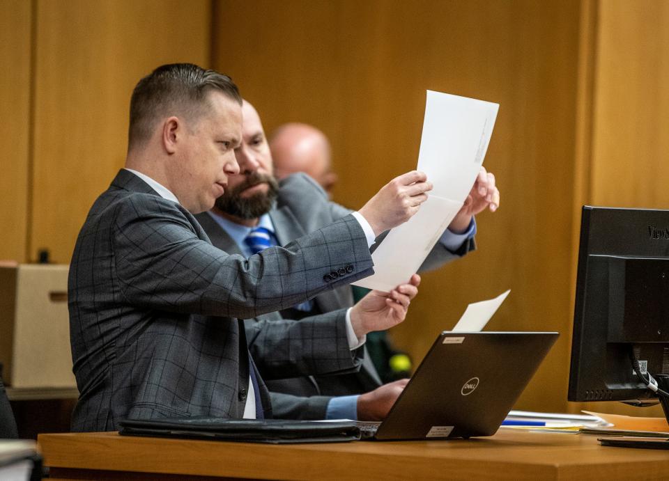 Assistant State Attorneys Michael Nutter and Mark Levine review crime-scene photos before the jury is present Tuesday.