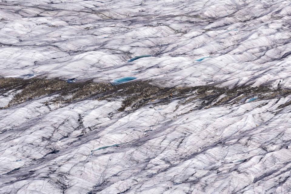 Snow melt forms small pools on the Aletsch Glacier near Goms, Switzerland, Wednesday, June 14, 2023. (AP Photo/Matthias Schrader)