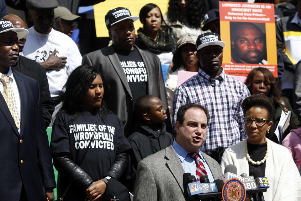 Martin Tankleff, bottom right, who was wrongfully convicted of murdering his parents in 1988, speaks as as a group of New York City men, who claim they were framed by a crooked police detective decades ago, voice their demand for prosecutors to speed up an ongoing review of the detective's cases at a rally on the steps of City Hall, Wednesday, April 9, 2014, in New York. They claim they were convicted on evidence fabricated by the now-retired detective, Louis Scarcella. (AP Photo/Jason DeCrow)