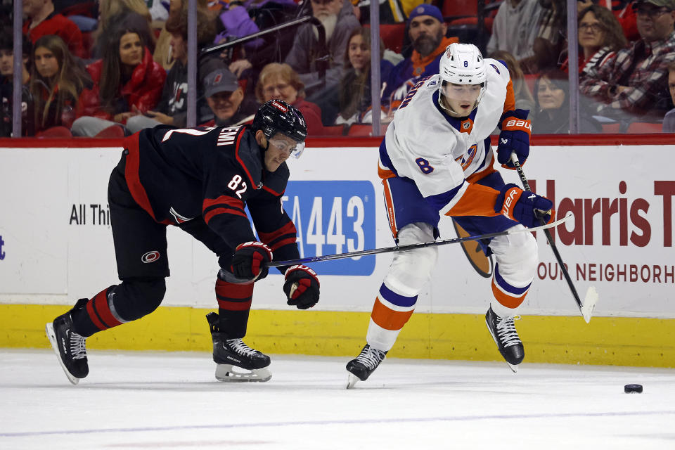 New York Islanders' Noah Dobson (8) skates the puck away from Carolina Hurricanes' Jesperi Kotkaniemi during the first period of an NHL hockey game in Raleigh, N.C., Thursday, Nov. 30, 2023. (AP Photo/Karl B DeBlaker)