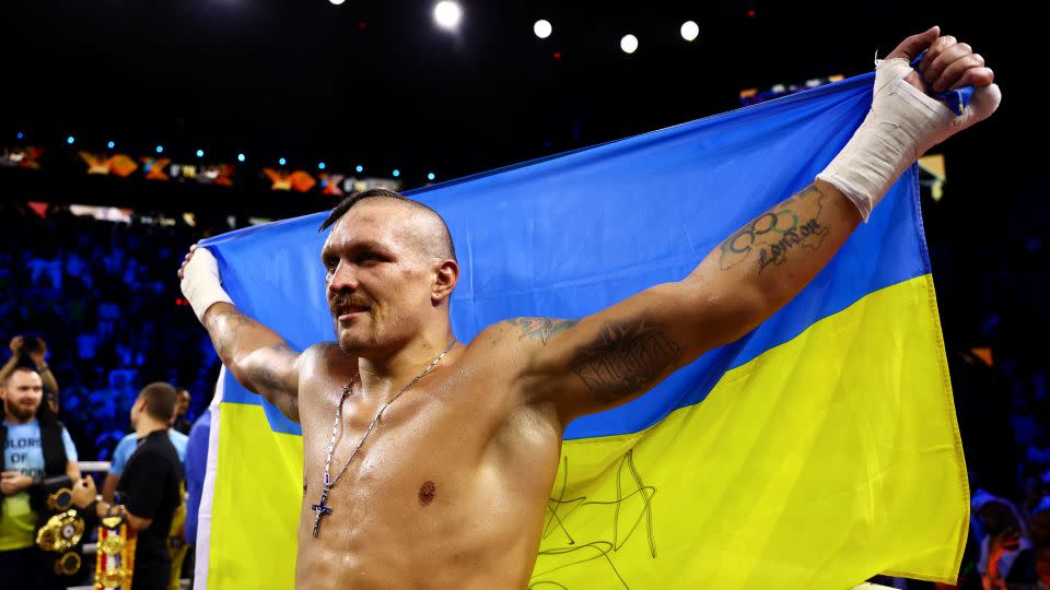 Usyk celebrates with an Ukrainian flag after beating Anthony Joshua in 2022. - Francois Nel/Getty Images