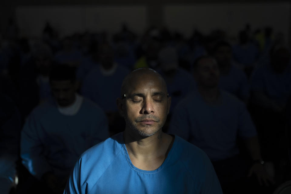 A shaft of light falls on 42-year-old prisoner Albert Barreto during a guided meditation session in Valley State Prison's gymnasium in Chowchilla, Calif., Friday, Nov. 4, 2022. The gym had been closed for recreational activities like basketball as part of ongoing COVID restrictions. About 150 prisoners were allowed in for the film – individual bags of buttered popcorn and cold beverages included with admission – their excitement palpable after many months of isolation. (AP Photo/Jae C. Hong)