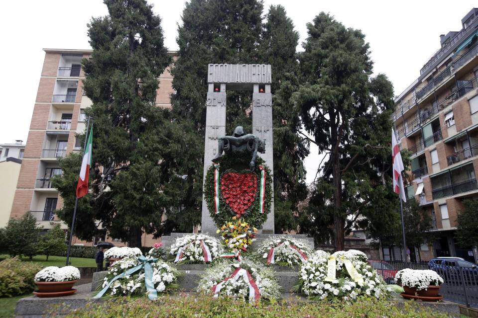 Flowers lie in front of a bronze ossuary monument entitled 'Ecco La Guerra', (Here is War) dedicated to the 'Little Martyrs of Gorla', in memory of a World War II bombing raid on Oct. 20 1944 is pictured in Milan, Italy, Sunday, Oct. 20, 2019. Milan's mayor Giuseppe Sala, following a Mass Sunday for the 75th anniversary of the raid, asked U.S. authorities to apologize for a World War II bombing raid that killed 184 elementary school children. (AP Photo/Luca Bruno)