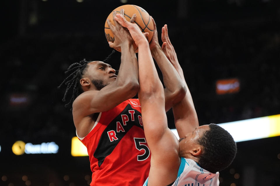 Charlotte Hornets forward Grant Williams, right, defends against Toronto Raptors guard Immanuel Quickley (5) during second-half NBA basketball game action in Toronto, Sunday, March 3, 2024. (Frank Gunn/The Canadian Press via AP)