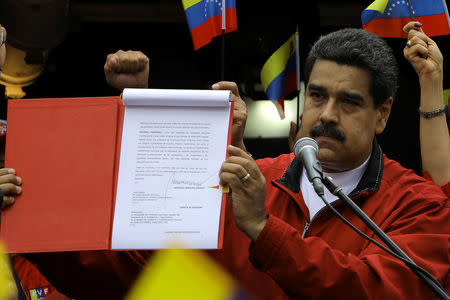 Venezuela's President Nicolas Maduro shows a document with the details of a "constituent assembly" to reform the constitution during a rally at Miraflores Palace in Caracas, Venezuela May 23, 2017. REUTERS/Carlos Barria