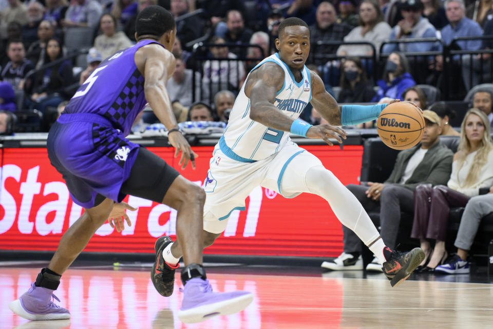 Charlotte Hornets guard Terry Rozier, right, dribbles past Sacramento Kings guard De'Aaron Fox during the first quarter of an NBA basketball game in Sacramento, Calif., Tuesday, Jan. 2, 2024. (AP Photo/Randall Benton)