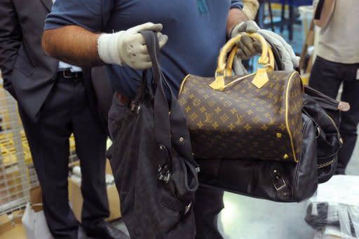 A French customs officer shows seized counterfeit handbags prior their destruction in May 2012. The counterfeiting of goods, according to the United Nations Office on Drugs and Crime, brought in $250 billion annually to organised crime groups