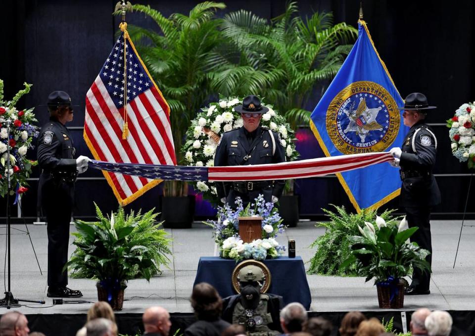 Officers begin to fold the flag during The Presentation of Flag ceremony at U.S. Marshal Thomas Weeks Jr.’s memorial service at Bojangles Coliseum in Charlotte, NC on Monday, May 6, 2024. The flag was presented to Weeks’ widow Kelly Weeks. U.S. Marshal Thomas Weeks Jr., died during a standoff with a gunman on Monday, April 29th 2024. Two other law enforcement officers were also killed in the shootout. CMPD Officer Joshua Eyer passed away later Monday evening from injuries sustained during the shootout.