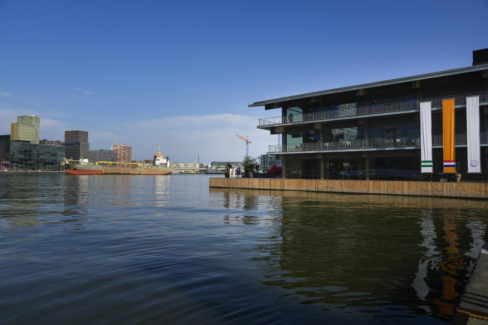 A dredger ship passes the Floating Office, right, where a high-Level dialogue on climate adaptation takes place in Rotterdam, Netherlands, Monday, Sept. 6, 2021. The dialogue, taking place just weeks before the COP26 UN climate change conference in Glasgow, will hammer out a clear call to action for governments, policy-makers and the public on what COP26 must deliver if communities are to be kept safe from the accelerating climate impacts in the coming decade. (AP Photo/Peter Dejong)