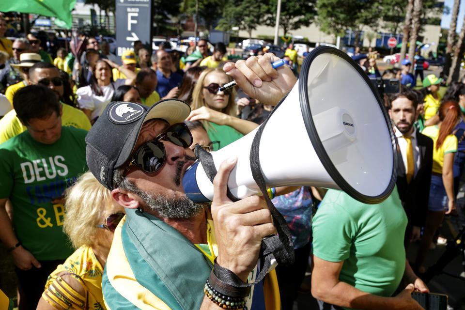 Supporters of Brazil's former President Jair Bolsonaro shout slogans outside the Liberal Party's headquarters where Bolsonaro arrived in Brasilia, Brazil, Thursday, March 30, 2023. Bolsonaro arrived back in Brazil on Thursday after a three-month stay in Florida. (AP Photo/Gustavo Moreno)