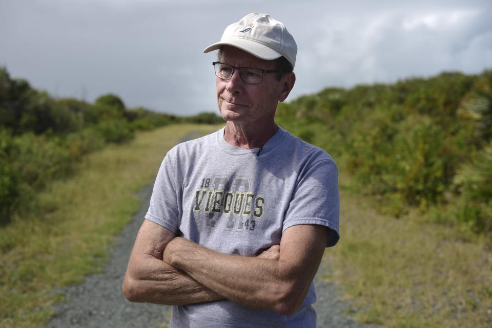 In this Jan. 13, 2017 photo, retiree Thomas Toaddy wears a Vieques T-shirt as he spends the afternoon with family and friends near Ferro Port lighthouse at Verdiales Key point on the south coast of Vieques island, Puerto Rico. Toaddy, from Cleveland, Ohio who moved to Vieques with his wife, said he prefers the Navy focus on underwater cleanup as he's eager to explore new beaches and coves. (AP Photo/Carlos Giusti)