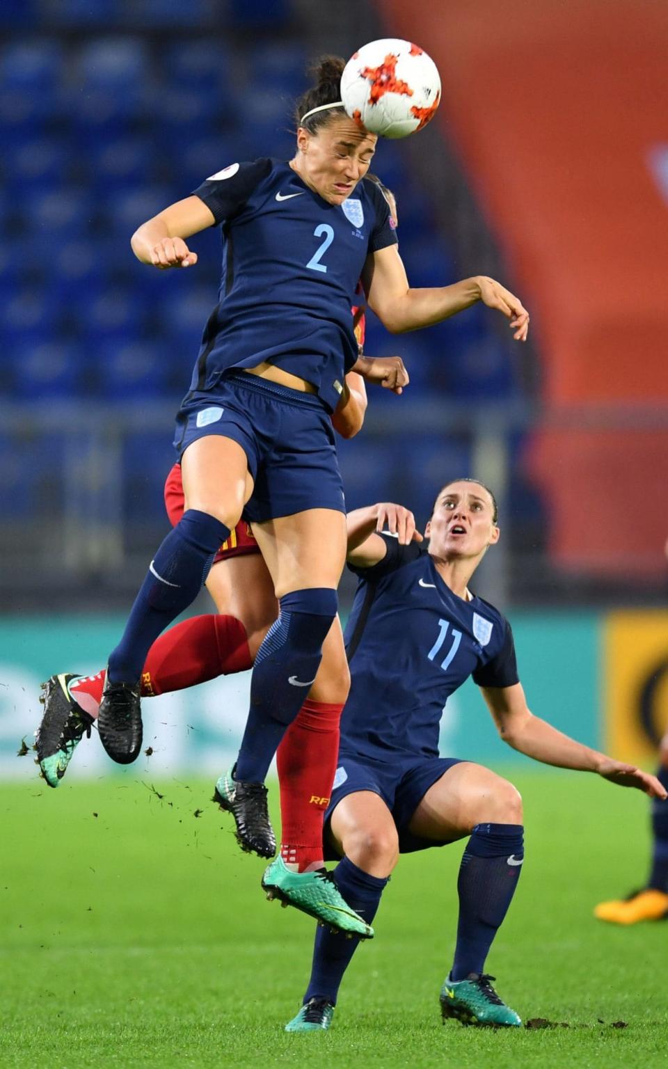 Lucy Bronze (front) climbs highest to head the ball away - Credit: AFP