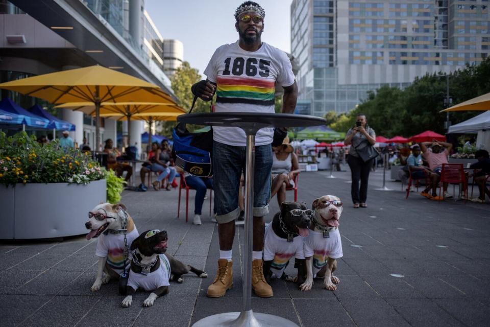 Casius Caligula watches a band with his pit bull dogs Mephistopheles, Maximilian, Medusa and Maleficent during Juneteenth festivities at Discovery Green in Houston, Texas, U.S., June 18, 2023.