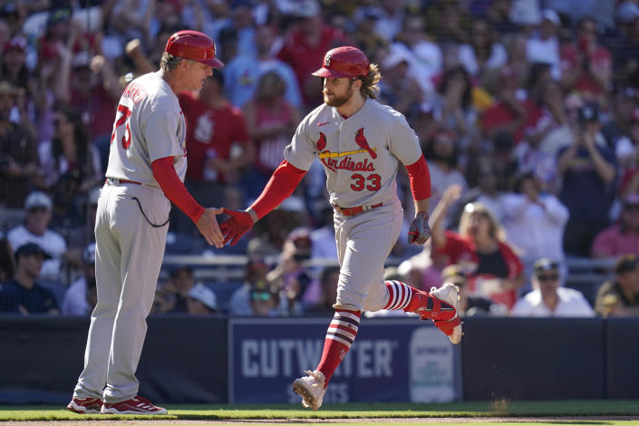 St. Louis Cardinals' Brendan Donovan, right, reacts with third base coach Ron 'Pop' Warner after hitting a grand slam during the seventh inning of a baseball game against the San Diego Padres, Thursday, Sept. 22, 2022, in San Diego. (AP Photo/Gregory Bull)