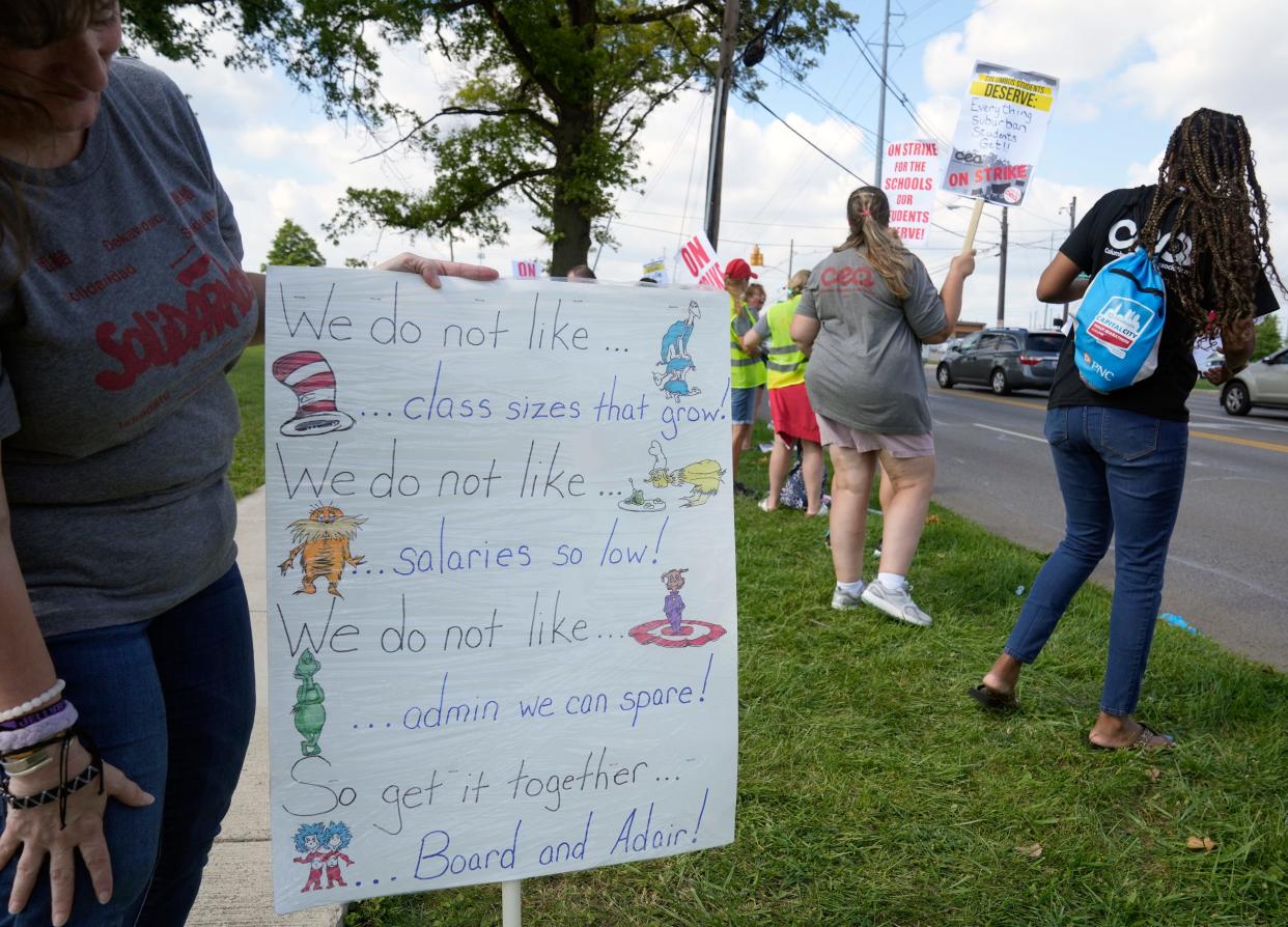 A Columbus Education Association member shows off a Dr. Seuss-inspired sign that includes a reference to salaries on the first day of the teachers strike Monday afternoon at Africentric Early College. Mandatory Credit: Barbara J. Perenic/Columbus Dispatch