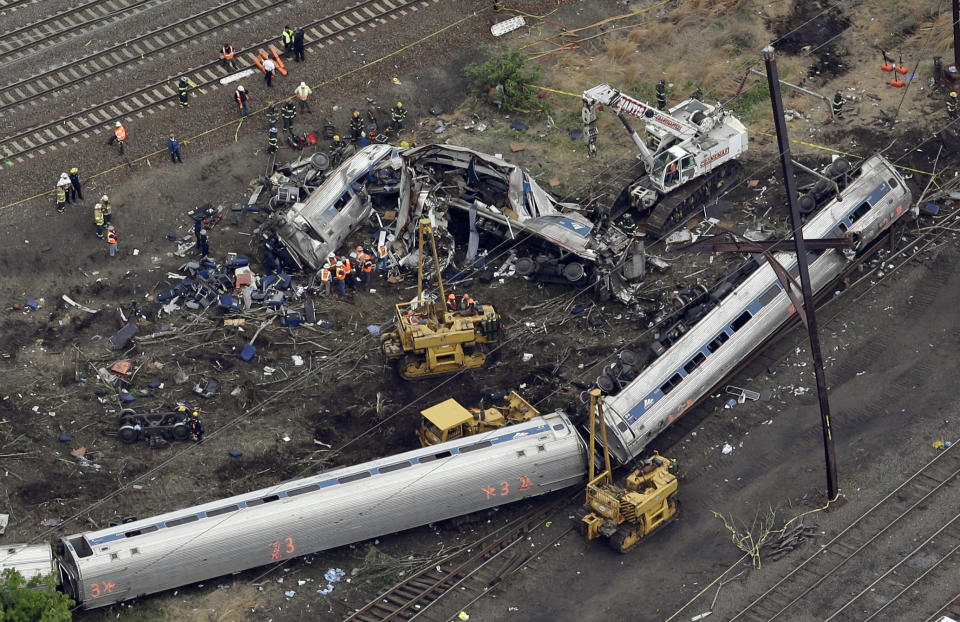 FILE – In this May 13, 2015, file photo, emergency personnel work near the wreckage of a New York City-bound Amtrak passenger train following a derailment that killed eight people and injured about 200 others in Philadelphia. Manslaughter charges filed against Amtrak engineer Brandon Bostian have been dropped for a second time. A defense lawyer argued Tuesday, July 23, 2019, that any mistakes made by Bostian do not amount to a crime, and a city judge agreed. The state Attorney General's Office says it will appeal the latest ruling.(AP Photo/Patrick Semansky, File)