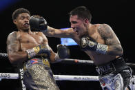 Oscar Valdez, right, throws a right at Shakur Stevenson during a WBC-WBO junior lightweight title boxing bout Saturday, April 30, 2022, in Las Vegas. (AP Photo/John Locher)