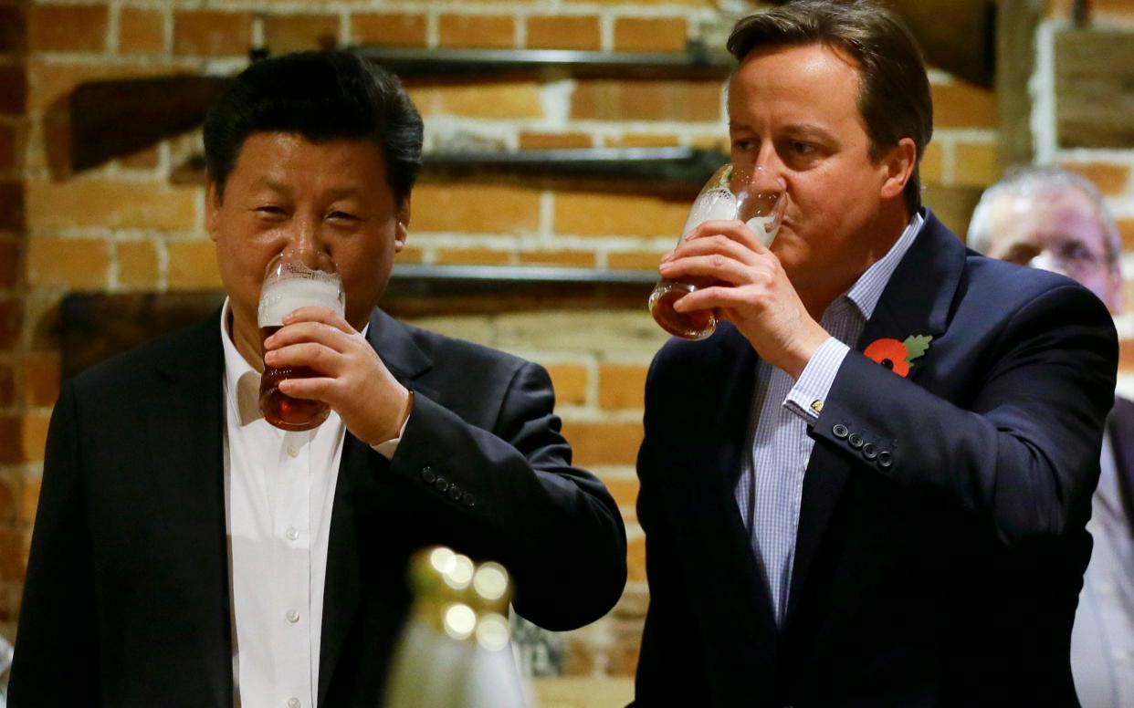 China's President Xi Jinping drinks a pint of beer with David Cameron during his visit to Britain in 2015 - Getty Images