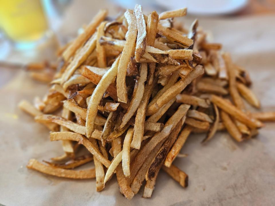 The hand-cut French fries at Central Cafe in Bradenton, paired with a pint of Beach Blonde Ale by 3 Daughters Brewing in St. Petersburg, photographed on July 2, 2024.