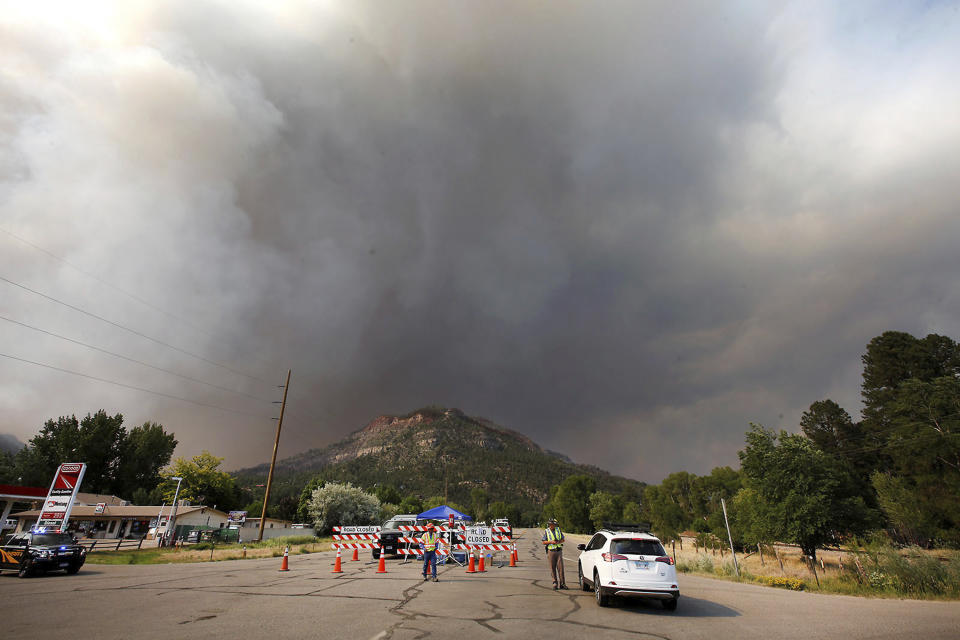 <p>Smoke rises from the 416 Fire behind the U.S. Highway 550 road block at Cometti Lane on Wednesday, June 13, 2018, near Durango, Colo. (Photo: Jerry McBride/The Durango Herald via AP) </p>