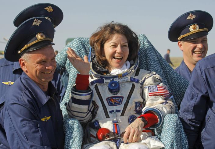 FILE - Russian space agency rescue team members carry U.S. astronaut Cady Coleman away from the landing site after the landing of the Soyuz capsule about 150 km (80 miles) south-east of the Kazakh town of Dzhezkazgan, Tuesday, May. 24, 2011. Russia will opt out of the International Space Station after 2024 and focus on building its own orbiting outpost, the country's newly appointed space chief said Tuesday, July 26, 2022. (AP Photo/Mikhail Metzel, File)