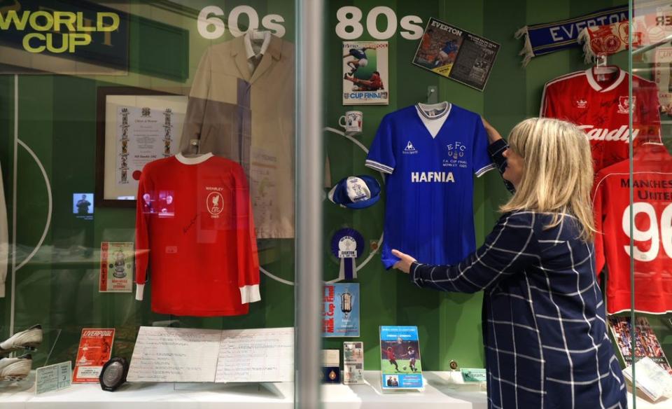 Curator Sharon Brown puts final touches to a football display case at the Museum of Liverpool’s Wondrous Place gallery (Gareth Jones/PA)