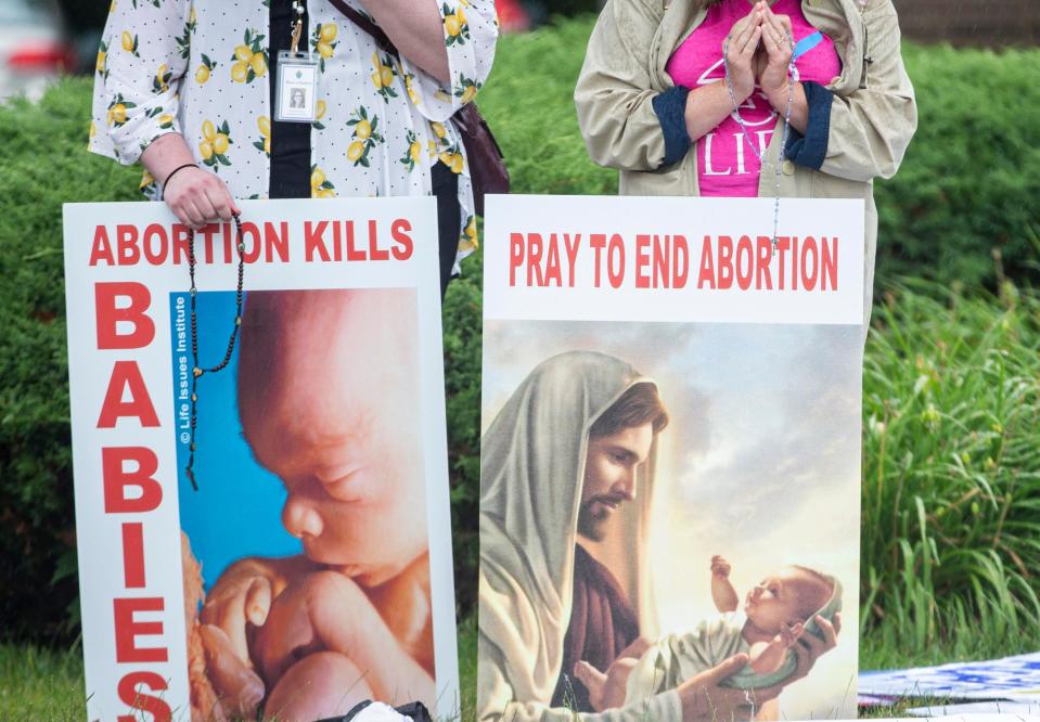 People holding signs and praying during an anti-abortion protest on Friday, July 8, 2022, in Rockford, outside a planned women's health center and abortion clinic, 4236 Maray Drive.