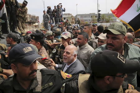 Iraq's Prime Minister Haidar al-Abadi (C) tours the city of Tikrit after Iraq security forces regained control from Islamic State militants, in this April 1, 2015 file photo. REUTERS/Stringer/Files